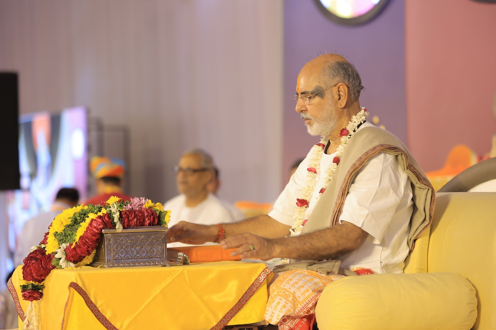 Pujya Bhaishri Rameshbhai Oza beside the sacred text and flowers at the Shrimad Bhagwat Katha in Nagpur.